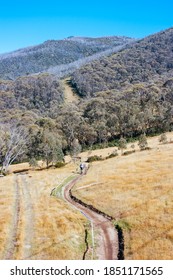 Mountain Bikers Descend Down Thredbo On A Cool Autumn Day In The Snowy Mountains, New South Wales, Australia