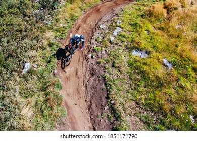 Mountain Bikers Descend Down Thredbo On A Cool Autumn Day In The Snowy Mountains, New South Wales, Australia