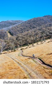 Mountain Bikers Descend Down Thredbo On A Cool Autumn Day In The Snowy Mountains, New South Wales, Australia