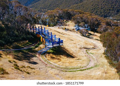 Mountain Bikers Descend Down Thredbo On A Cool Autumn Day In The Snowy Mountains, New South Wales, Australia