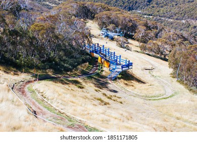 Mountain Bikers Descend Down Thredbo On A Cool Autumn Day In The Snowy Mountains, New South Wales, Australia