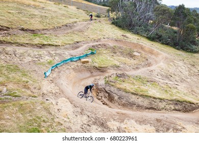 Mountain Bikers Descend Down Thredbo On A Cool Autumn Day In The Snowy Mountains, New South Wales, Australia