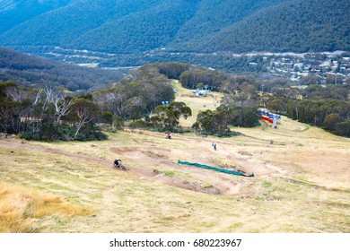 Mountain Bikers Descend Down Thredbo On A Cool Autumn Day In The Snowy Mountains, New South Wales, Australia