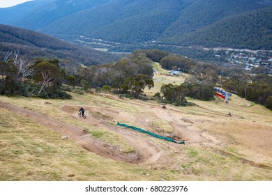 Mountain Bikers Descend Down Thredbo On A Cool Autumn Day In The Snowy Mountains, New South Wales, Australia