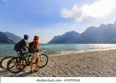 Mountain Biking. Couple With Bikes On Lake Garda, Riva Del Garda, Italy.