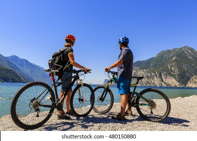 Mountain Biking. Couple With Bikes On Lake Garda, Riva Del Garda, Italy.