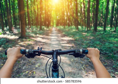 Mountain biking down hill descending fast on bicycle. View from bikers eyes. - Shutterstock ID 585783596