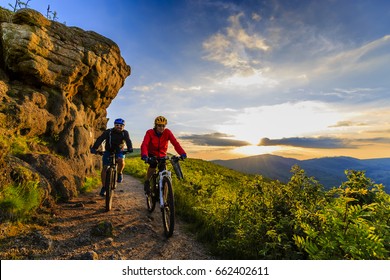 Горный велосипед женщины и мужчины езда на велосипедах на закате горы лесной пейзаж. Пара Велоспорт MTB эндуро потока трек. Спорт на свежем воздухе.