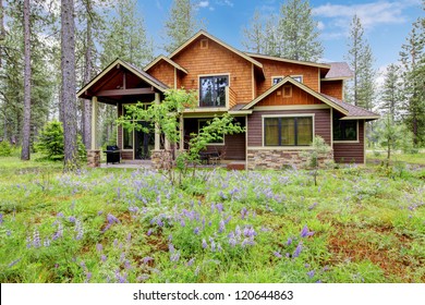 Mountain Cabin Home Wood Exterior With Forest And Flowers.