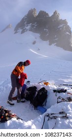 mountain climber getting ready for a cold bivy night in a snowhole on a glacier in the Alps