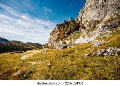 Mountain Climber On A Steep And Exposed Via Ferrata Col Dei Bos Near Passo Falzarego. Majestic Landscape Of Alpine Red Autumn Passo Falzarego, Tofana. Italy Near Cortina D'Ampezzo