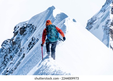 Mountain climber on a steep narrow snow ridge, extreme alpinist mountaineer, Monch, Bernese Alps, Swiss - Powered by Shutterstock