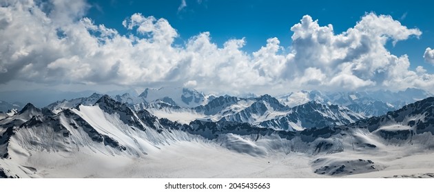 Mountain clouds over beautiful snow-capped peaks of mountains and glaciers. View at the snowy mountains. - Powered by Shutterstock