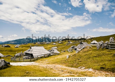 Mountain cottage hut or house on hill Velika Planina alpine meadow landscape. Eco farming. Travel destination for family hiking. Kamnik Alps, Slovenia. Big Plateau.