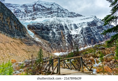Mountain crossing over a mountain pass. Wooden bridge in mountains. Mountain pass way. Snowy mountain rock