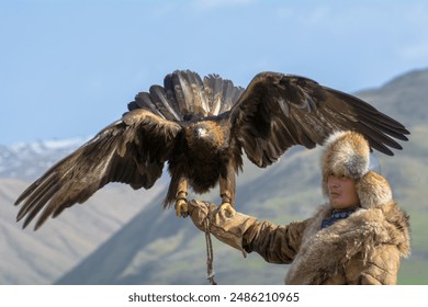 Mountain eagle sitting on the hand of a Kyrgyz man.
