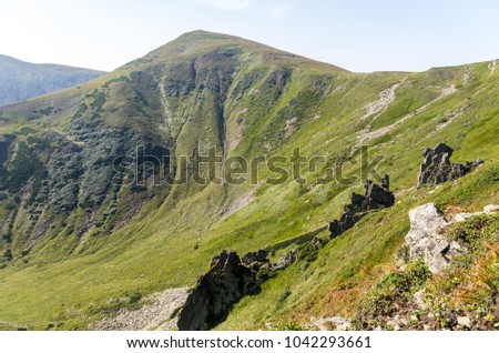 Mountain in the form of a triangle. Green mountain.