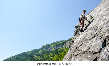 Mountain Guide Rock Climber On A Slab Limestone Climbing Route In The Alps Of Switzerland On A Beautiful Day