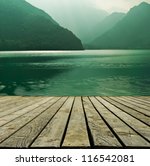 Mountain lake and flowing river with a wooden bridge