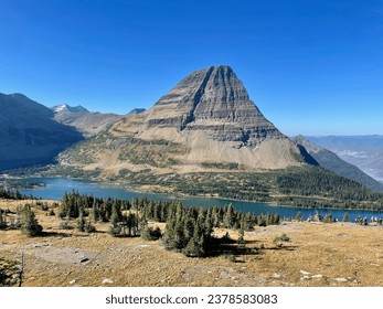 a mountain with a lake and a mountain range in the background