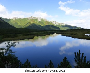 Mountain lake with reflection of distant peaks