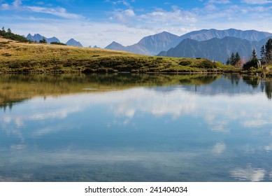 Mountain lake with reflection of the sky and clouds