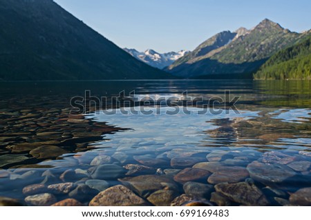 Mountain lakes filled with clean water from melting snow pack fill the wilderness scenery. Multinskoe lake mend the Altai mountains Siberia Russia