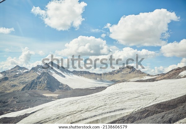 Mountain\
landscape of bare rocks with snow lying on\
them.