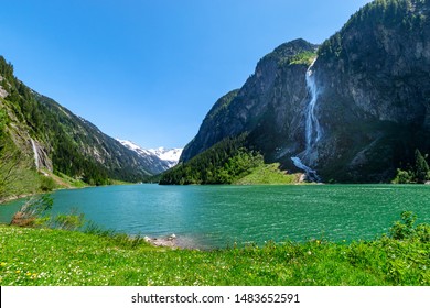 Mountain landscape with clear turquoise lake and waterfall in the Alps. Zillertal Alps Nature Park, Austria, Tyrol.