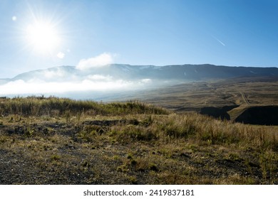 Mountain landscape with clouds and sun in a blue sky, Iceland