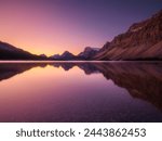 Mountain landscape at dawn. Sunbeams in a valley. Lake and high peaks in a mountain valley at dawn. Natural landscape with bright sunshine. High rocky mountains.