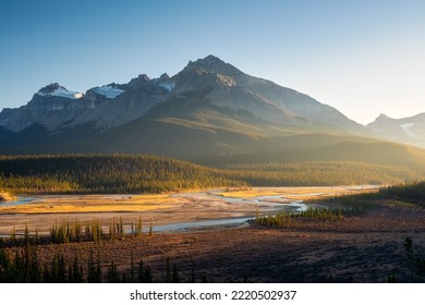 Mountain landscape at dawn. Sunbeams in a valley. Rivers and forest in a mountain valley at dawn. Natural landscape with bright sunshine. High rocky mountains. Banff National Park, Alberta, Canada.  - Shutterstock ID 2220502937