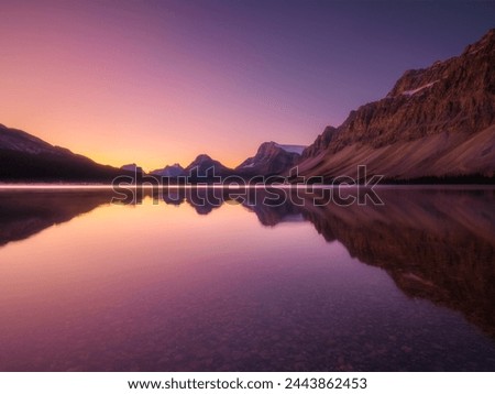 Mountain landscape at dawn. Sunbeams in a valley. Lake and high peaks in a mountain valley at dawn. Natural landscape with bright sunshine. High rocky mountains.