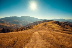 Mountain Landscape On A Sunny Day In Autumn. View Of The Mountain Slopes And Dirt Road. Beautiful Nature Landscape. Carpathian Mountains. Ukraine