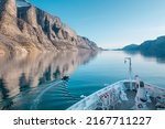 Mountain landscape with reflection.  Expedition cruise ship in Sam Ford Fjord, Baffin Island in Nunavut, Arctic Canada