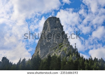 Mountain landscape with mountain rocks, rocky formations surrounded by forests and clouds. Cheile Bicazului, Hasmas Mountains, Carpathian.  Mountain under the blue sky. Stone and clouds, mountain view