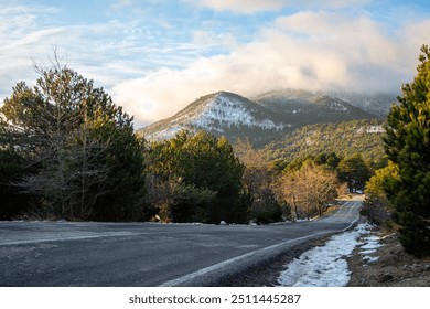 Mountain landscape with snow and pine trees at sunset in winter.Mountains in the clouds.  Snow-capped mountain road in the winter.  - Powered by Shutterstock