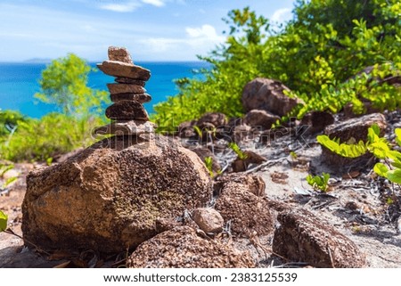 Mountain landscape with stone cairn on a sunny summer day. Praslin, Seychelles