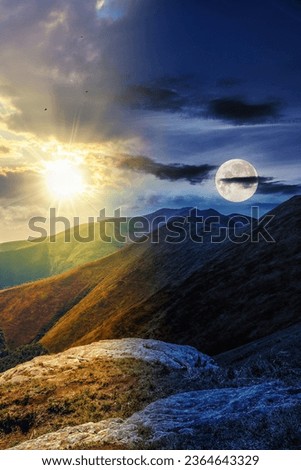 mountain landscape with stones among the grass on top of the hill under the cloudy summer sky with sun and moon at twilight. day and night time change concept. mysterious scenery in morning light