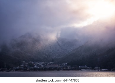 Mountain in low lying cloud and snow with the village shrouded in mist a scenic landscape view at Japan. travel Winter landscape in japan.