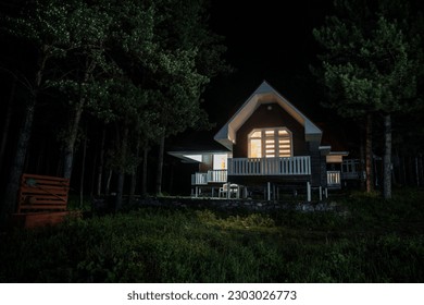 Mountain night landscape of building at forest at night with moon or vintage country house at night with clouds and stars. Cold Autumn night - Powered by Shutterstock