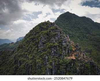 Mountain pass on the Ha Giang Loop with Vietnamese flag waving on top of the rock formations. This pass marks the fronteer between China and Vietnam - Powered by Shutterstock