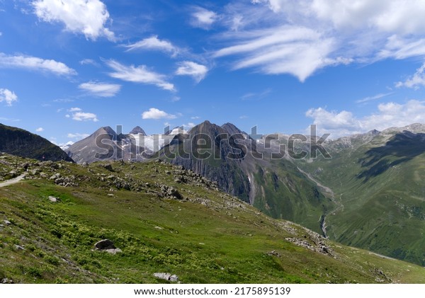 Mountain pass road at Nufenen\
Pass in the Swiss Alps with beautiful view of the Swiss alps on a\
sunny summer day. Photo taken July 3rd, 2022, Nufenen Pass,\
Switzerland.