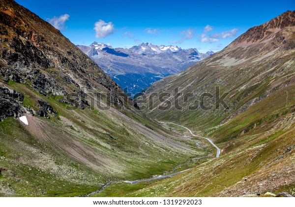 A\
mountain pass with views of the mountains in Austria. Mountain road\
going into the distance on a Sunny day in\
Austria\
