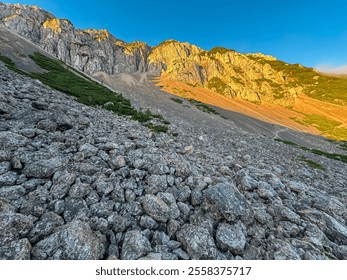 Mountain peak Begunjscica bathed in warm sunrise light seen from Loibl Pass in Karawanks, border Slovenia Austria. Wanderlust in Austrian Slovenian Alps. Tranquil atmosphere in alpine wilderness. Hike - Powered by Shutterstock