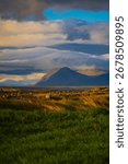 Mountain Peak with Dramatic Clouds and Green Fields in Iceland