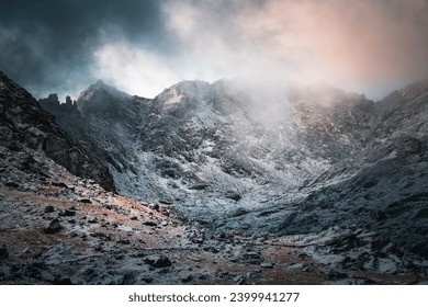 
Mountain peak during winter, landscape covered in snow during sunrise.