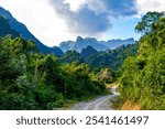 Mountain peak landscape with tropical forest jungle hills rocks and walking hiking path street road in Vang Vieng Vientiane Province Laos in Southeastasia Asia.