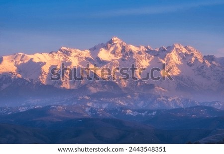 Mountain peak Nursultan former Komsomol, a beautiful mountain in the snow at sunset over the city of Almaty in Kazakhstan
