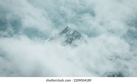 Mountain peak peeking through clouds